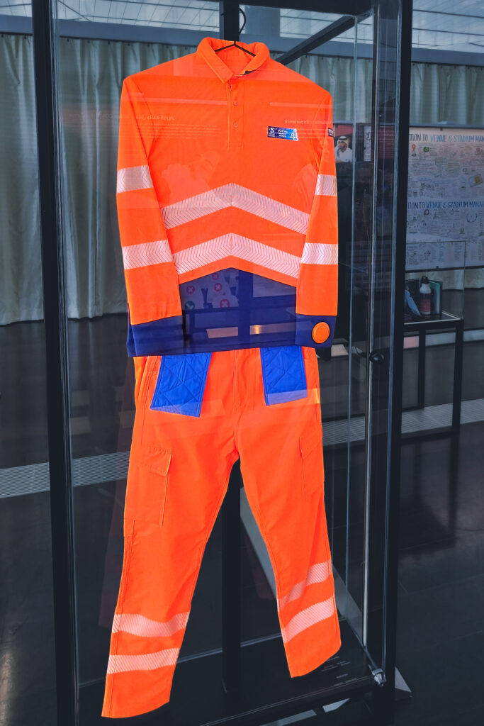 An orange cooling jumpsuit in a museum display case.