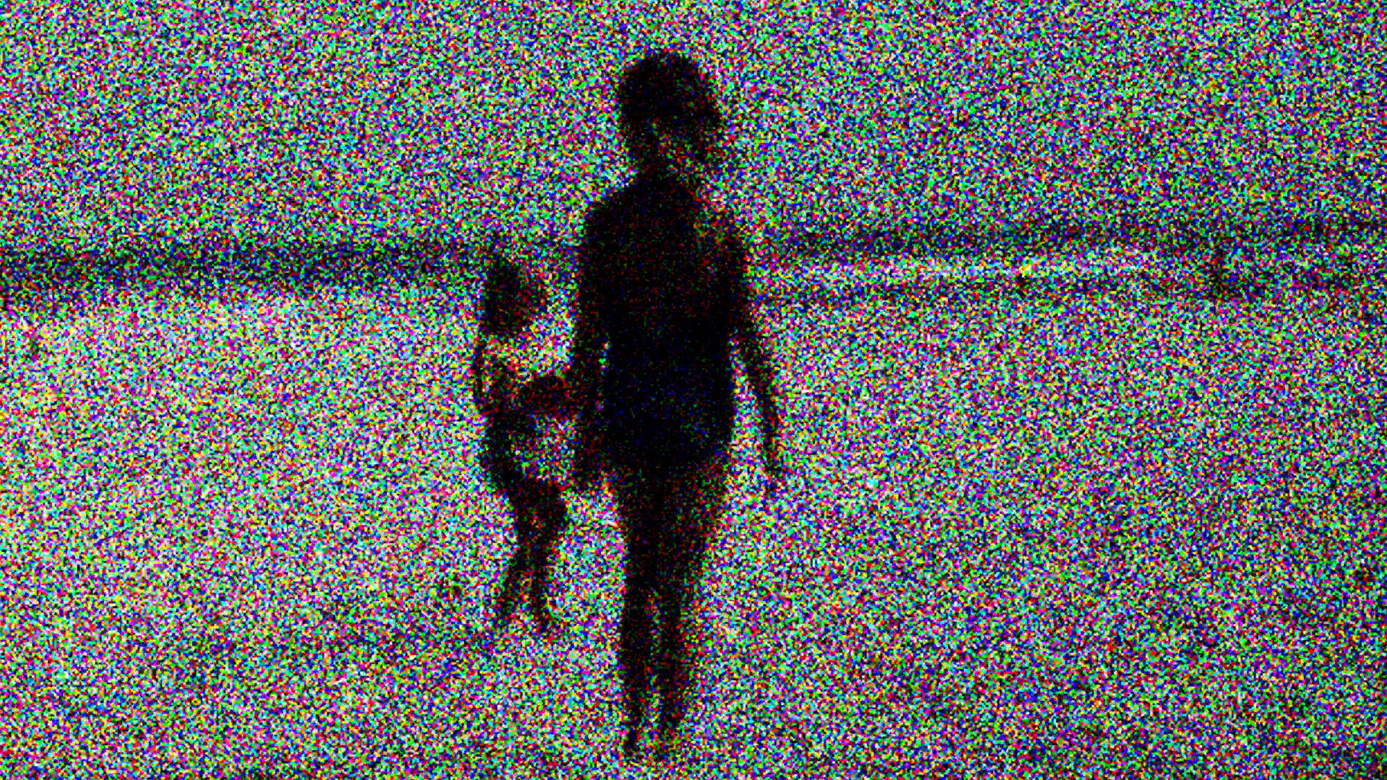 Two blurred people in a highly pixelated beach scene