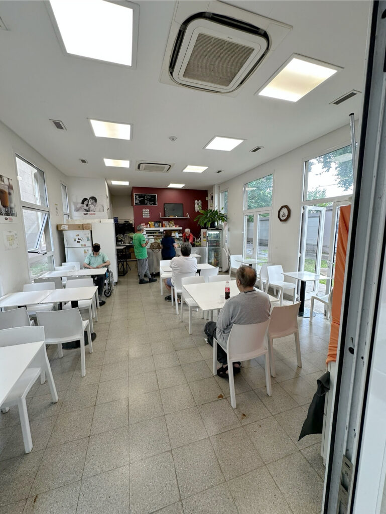 A cafeteria with neat rows of white tables and chairs