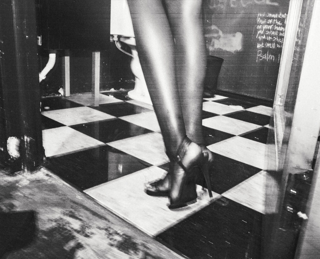 footsteps of high heels walking across checker-board floor in black and white