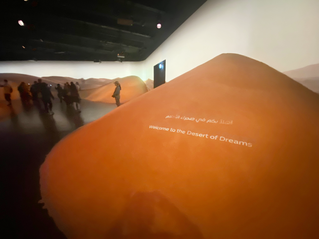 exhibit photo depicting people and an orange desert