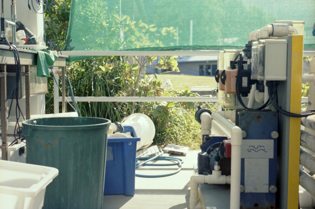 plastic pipes, bins, and connected equipment in an outdoor setting