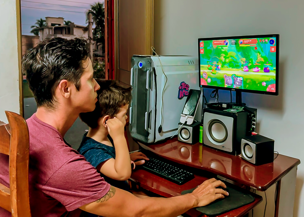 man with child in lap at home computer