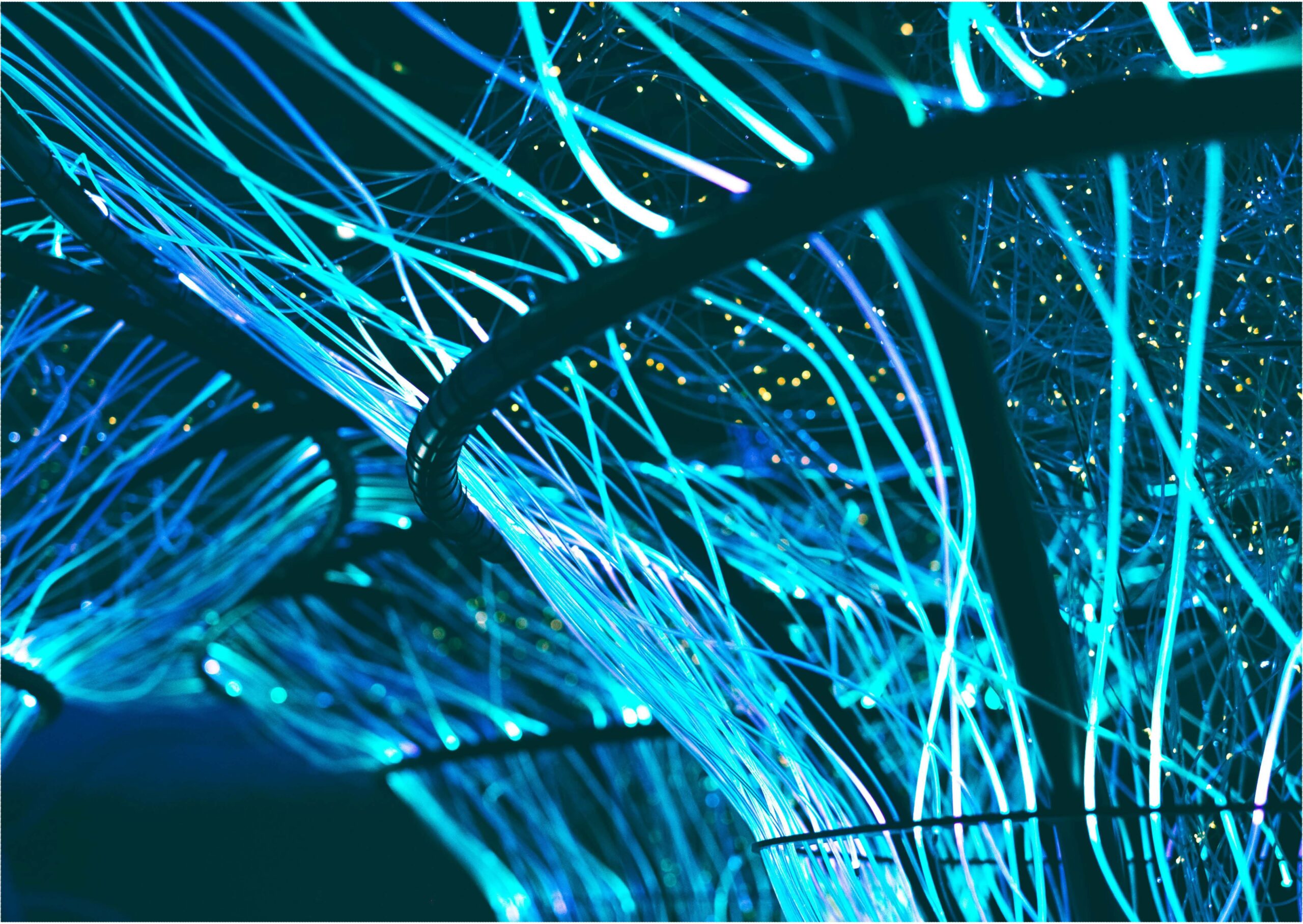 Image of dark structure with glowing blue cables against a dark/black night sky.