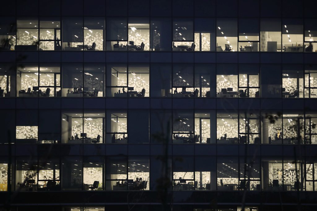 outside view of multi-story office building at night, with lights in offices
